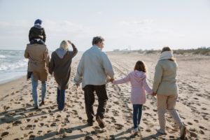 multigenerational family walking on beach for family office wealth management blog
