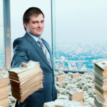 tax planning can save you money like the man shown in office holding and surrounded by money