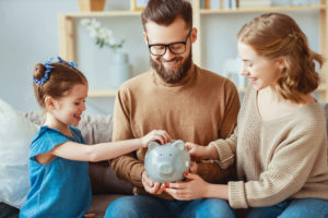family putting money into piggy bank for women investors of the future - stableford
