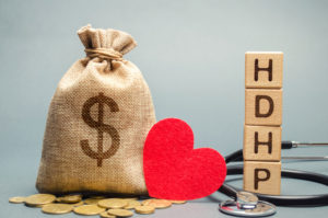 insurance planning with high deductive health plan wooden blocks and bag of money and heart