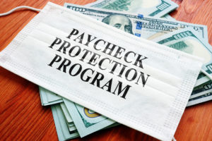paycheck protection program written on mask with money in the background
