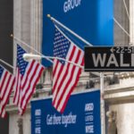 Market Commentary May 2020 Wall St sign with American flags in the background