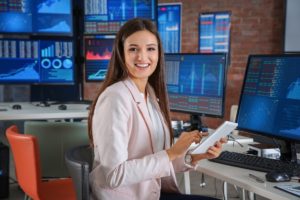 Woman financial advisor working in front of multiple stock market computer screens - wen