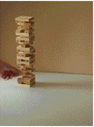 Beige image of someone playing a game of Jenga with a tower stacked very high on a white table