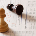 two chess pieces on a background of stock graphs